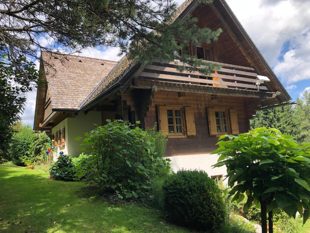 a large wooden house with a green yard at Charmantes Bauernhaus in erhöhter Aussichtslage in Modriach