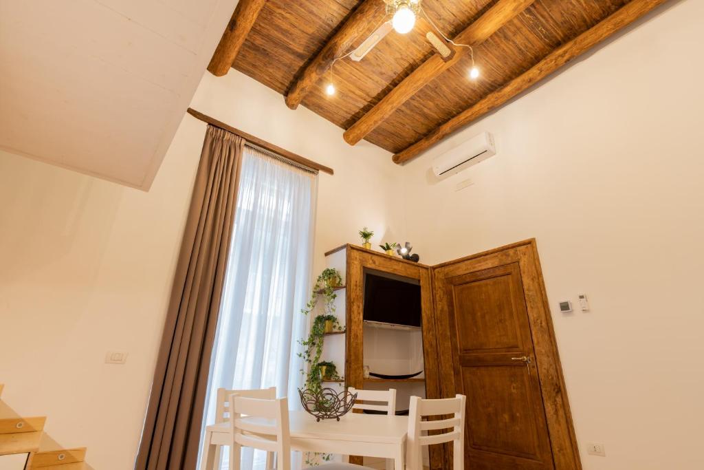 een eetkamer met een witte tafel en stoelen bij Casa Materdei in Napels
