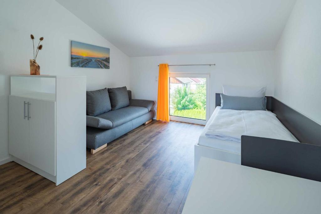 - un salon avec un lit et un canapé dans l'établissement Boardinghouse Kastanienring, à Reichertshausen
