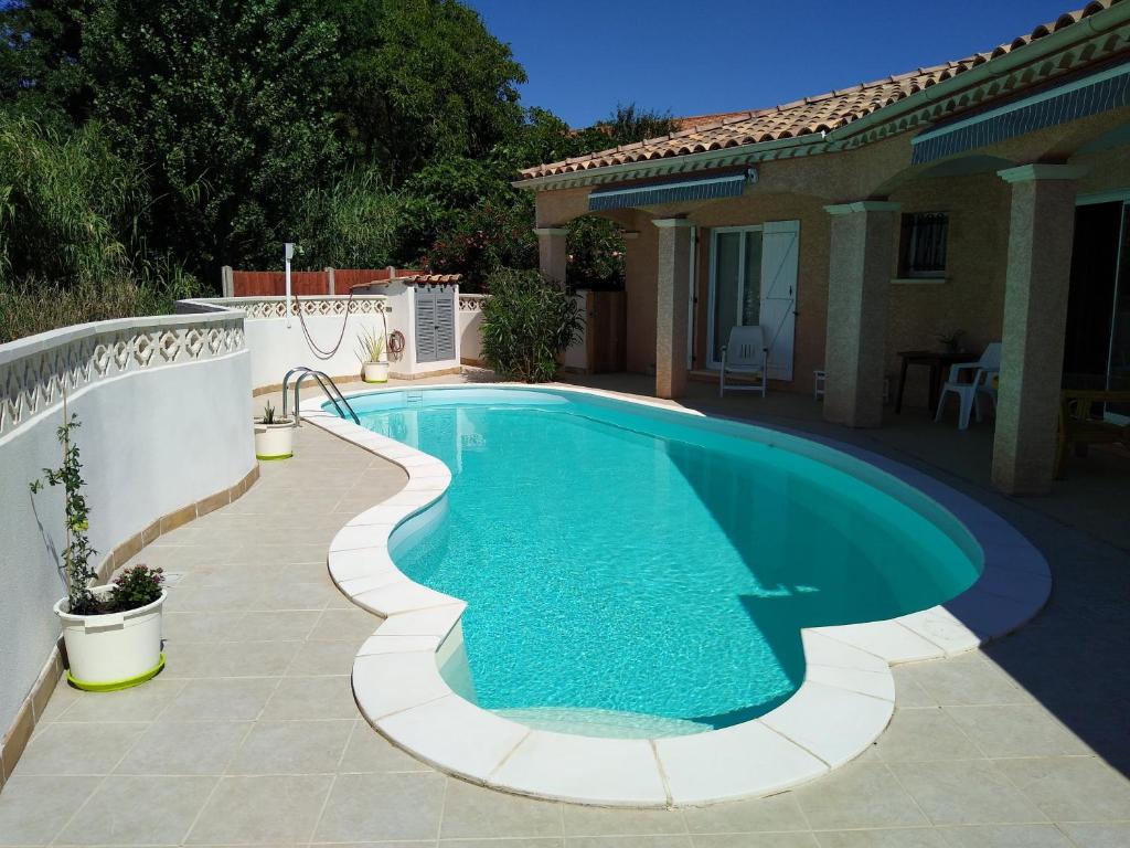 a swimming pool in a backyard with a house at Poppey in Péret