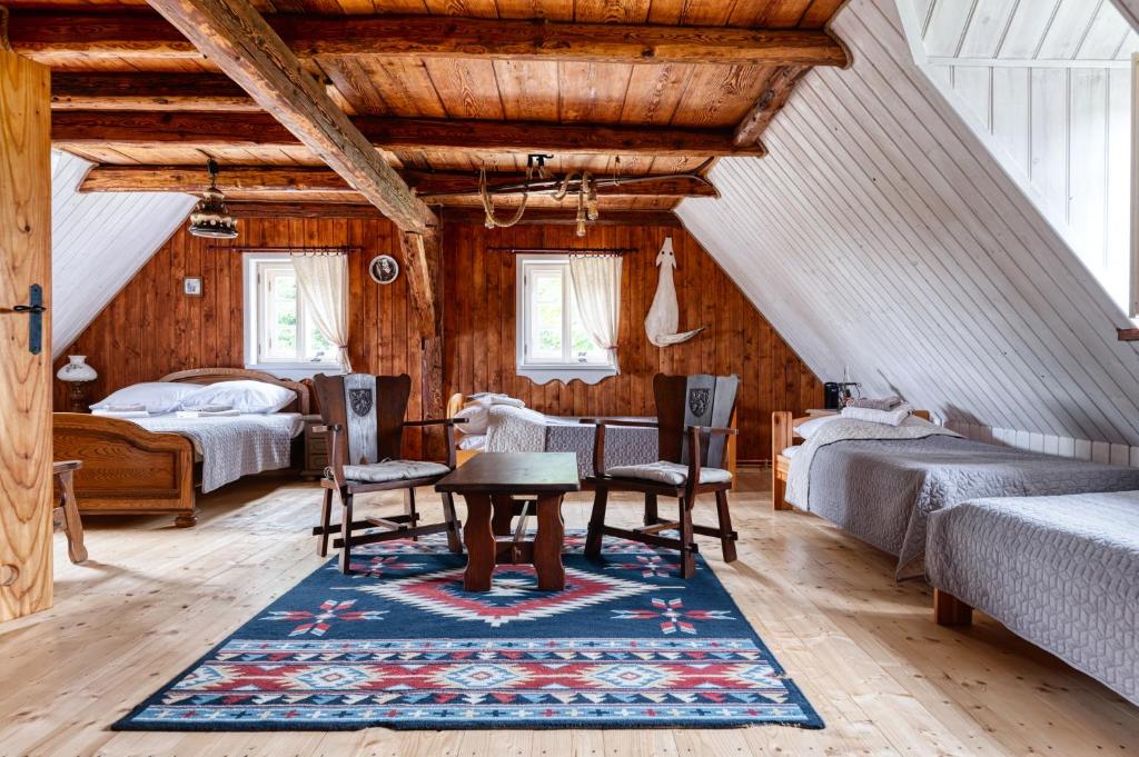 a attic bedroom with a table and two beds at Dom pod Mandragorą in Świeradów-Zdrój