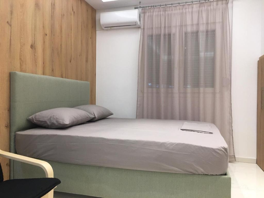 een slaapkamer met een bed en een raam met een laptop erop bij LUXURY IPOGA in Athene