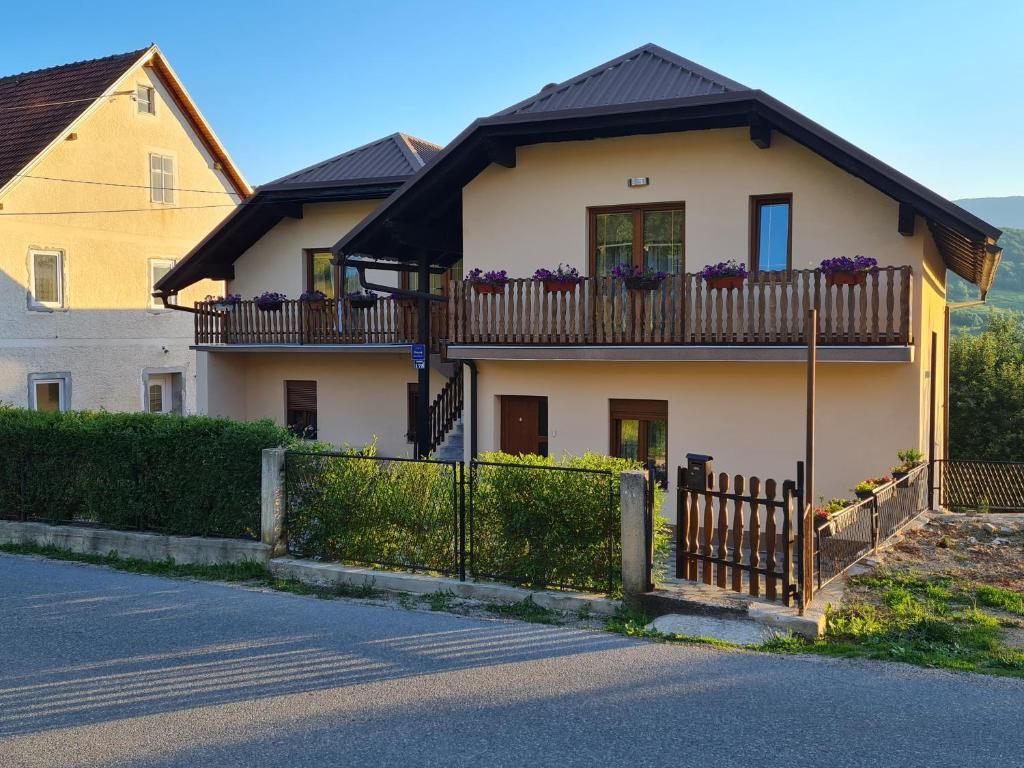 a house with a balcony with purple flowers on it at Apartman Nika in Otočac