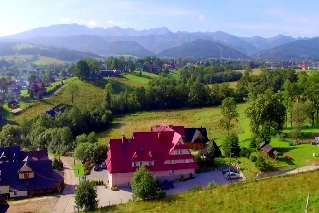 ザコパネにあるTatrzańska Rezydencja pod Brzyzkiemの山を背景にした畑の家