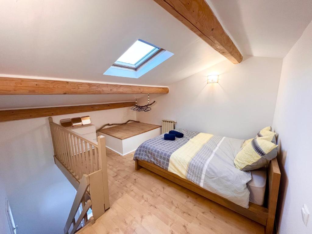 een kleine slaapkamer met een bed en een trap bij Appartement avec terrasse arborée proche LOURMARIN in Cadenet