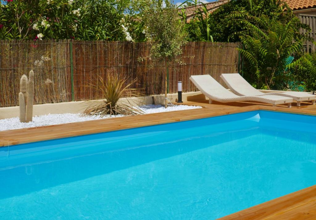 a swimming pool in a yard with chairs and a fence at Sacré Coeur d&#39;Ambrussum in Lunel