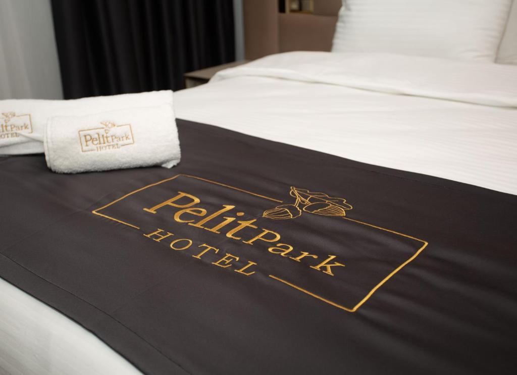 een hotelkamer met een zwart-gouden deken op een bed bij Pelit Park Hotel in Trabzon