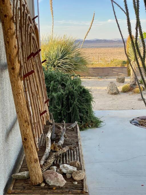 a wooden bench sitting on the side of a house at The Outpost Joshua Tree: Hot Tub, GameRoom, JTNP in Joshua Tree