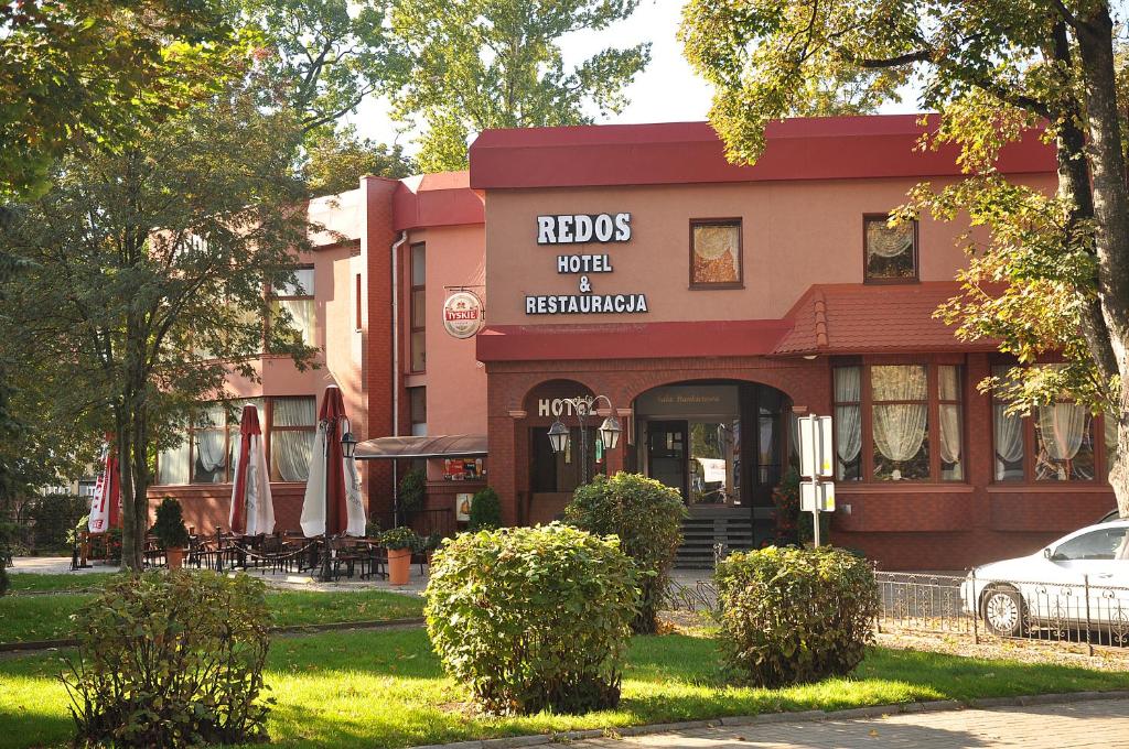 um edifício com um carro estacionado em frente em Hotel Restauracja Redos em Nysa