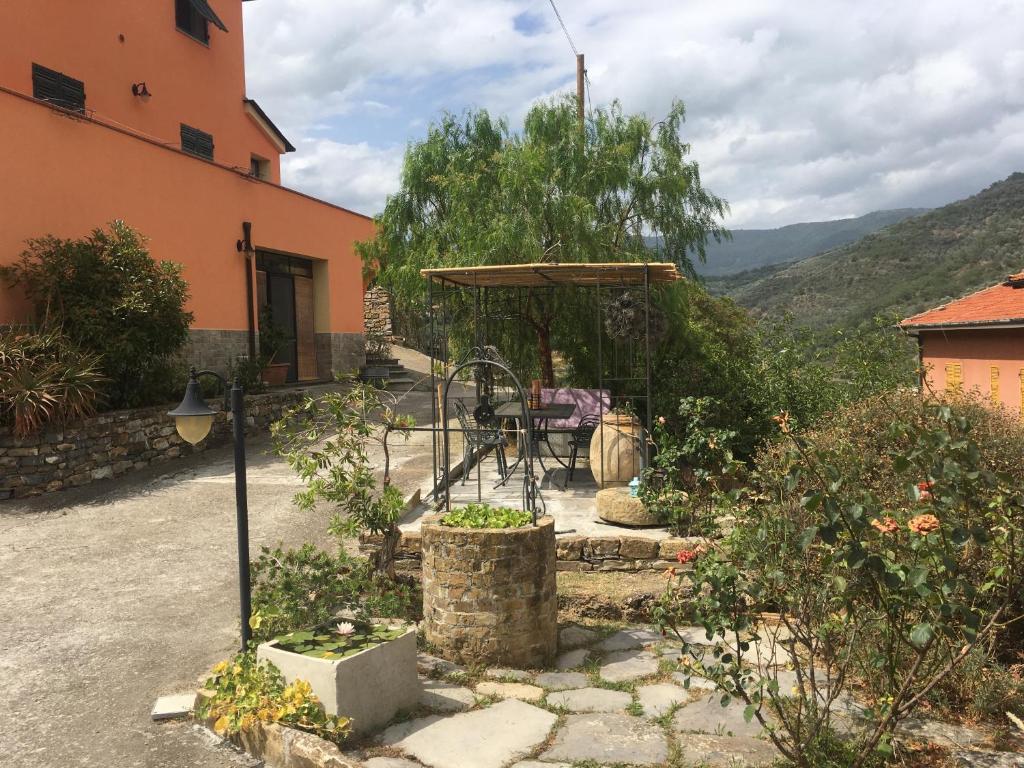 une terrasse d'une maison avec une table et un parasol dans l'établissement Olivo Al Mare - by Host4U, à Dolcedo