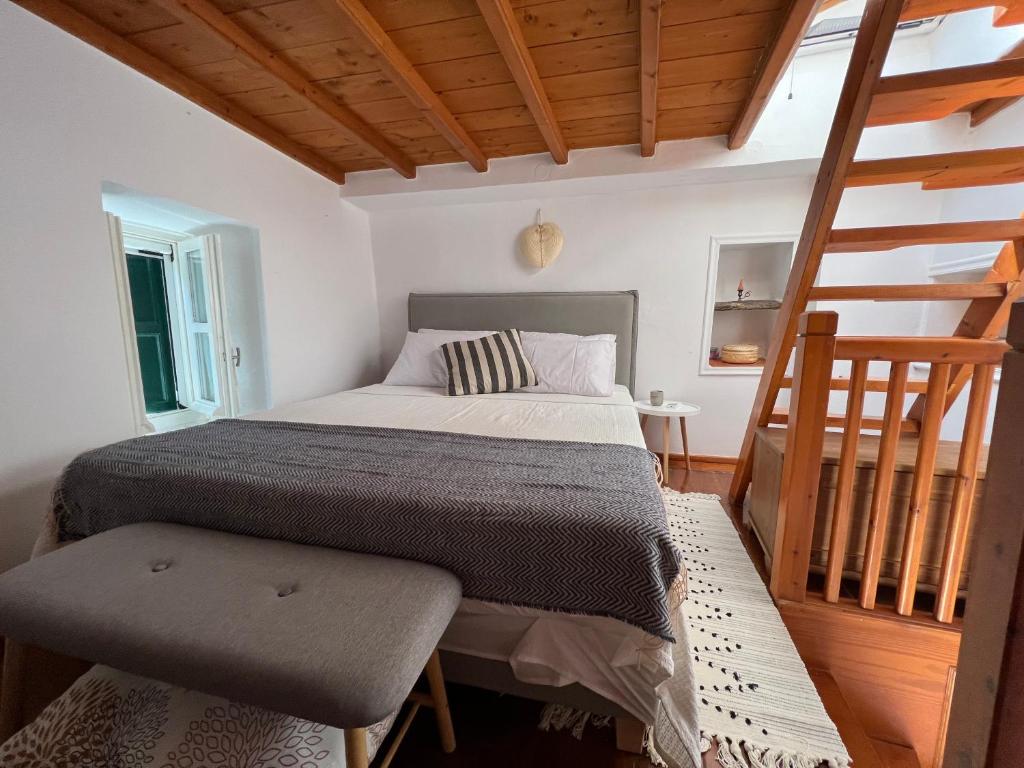 a bedroom with a bed and a wooden staircase at Elia Concept Apartments in Ano Syros
