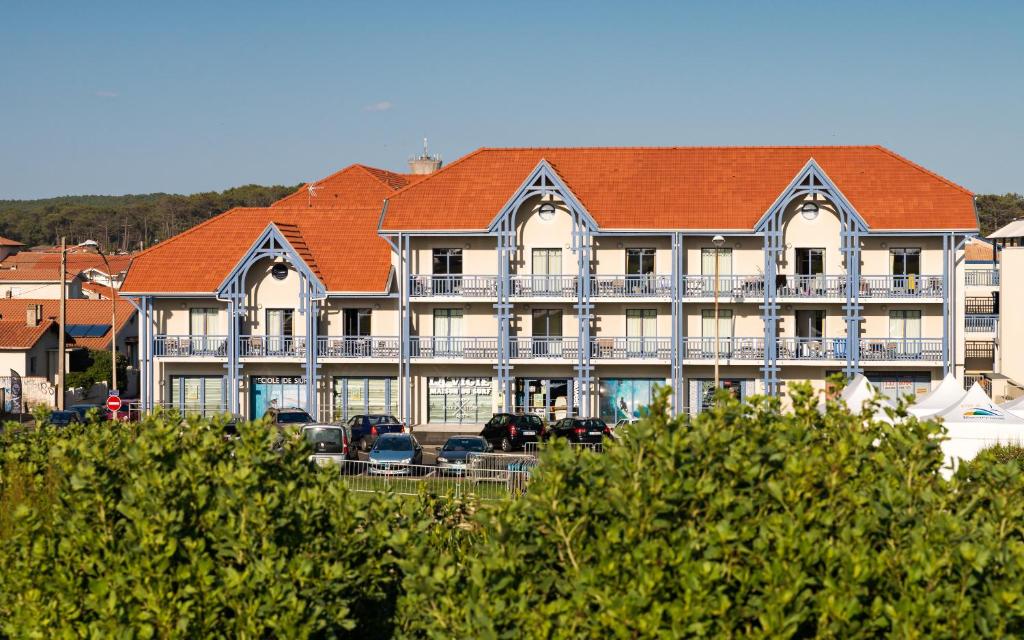 a large building with cars parked in front of it at Lagrange Vacances Les Balcons de l'Océan in Biscarrosse