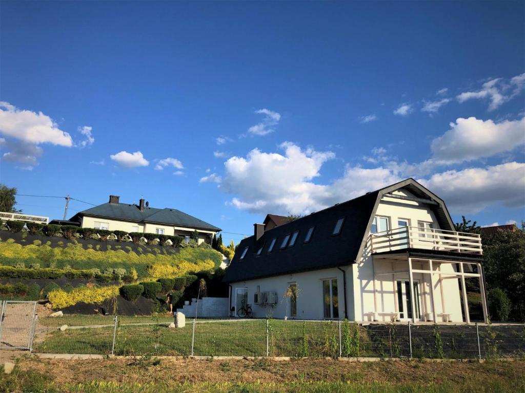 a white house with a black roof and a vineyard at Pokoje Gościnne AKWARELA in Tarnobrzeg