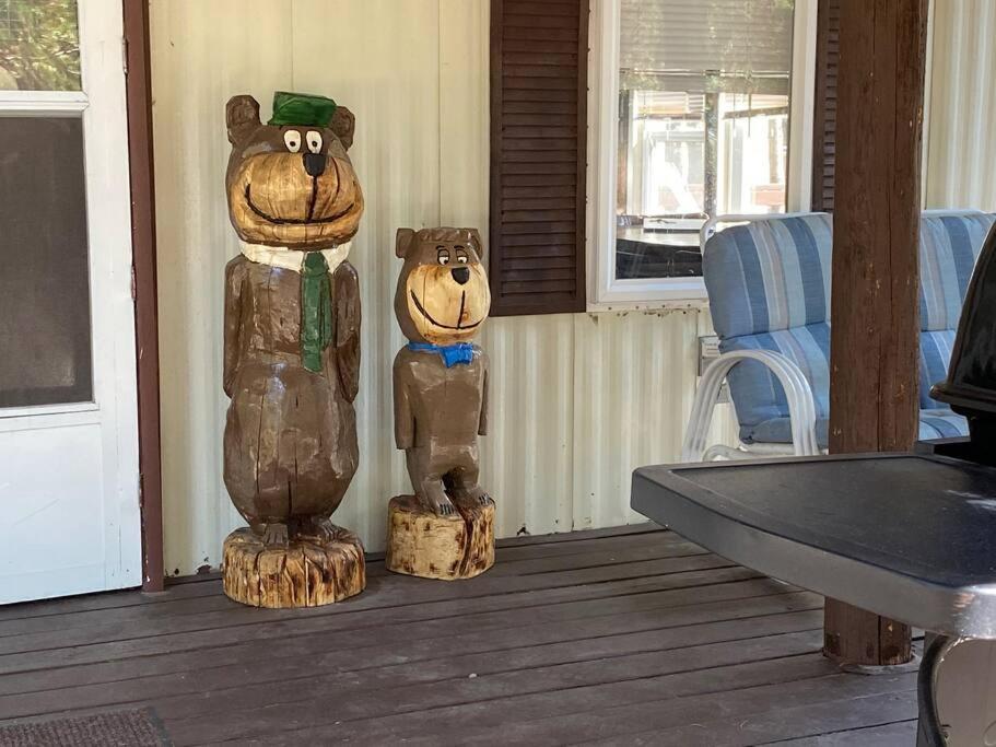 zwei hölzerne Bärenstatuen auf einer Veranda in der Unterkunft Grandma's Home in the Woods. Yellowstone in Island Park