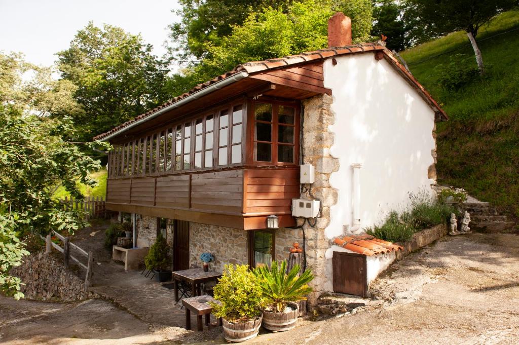 Una pequeña casa con un balcón en el lateral. en Casa Rural El Corquieu de la Cava, en San Feliz