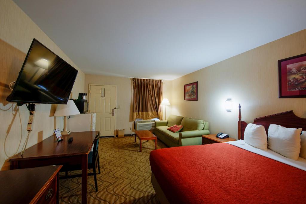 a hotel room with a bed and a living room at Brentwoodinn&suites in Glen Allen