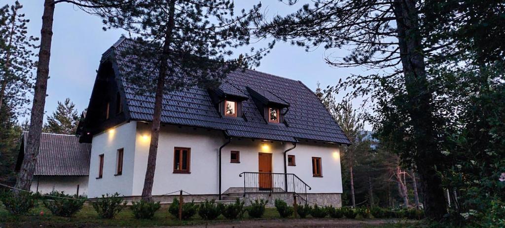 una casa blanca con techo negro con luces encendidas en Plitvice Story en Plitvička Jezera