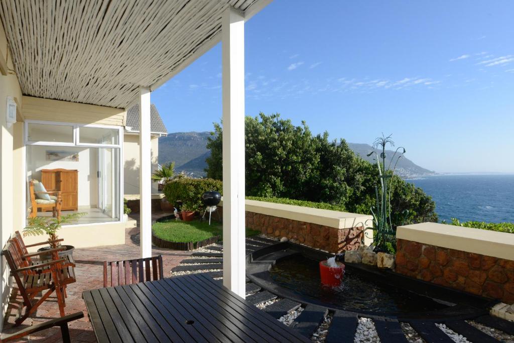 a patio with a table and a view of the ocean at A Whale of a Time in Fish Hoek