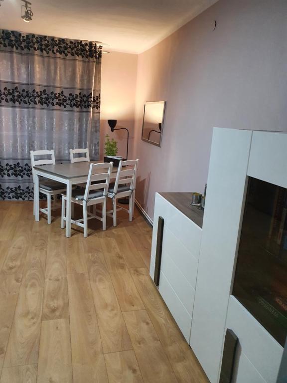 a kitchen and dining room with a table and chairs at Apartament Mario in Kolno