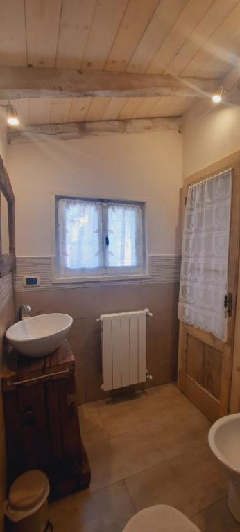 baño con lavabo, ventana y radiador en La Corte dei Cerri, Il Tornio, en Spervara