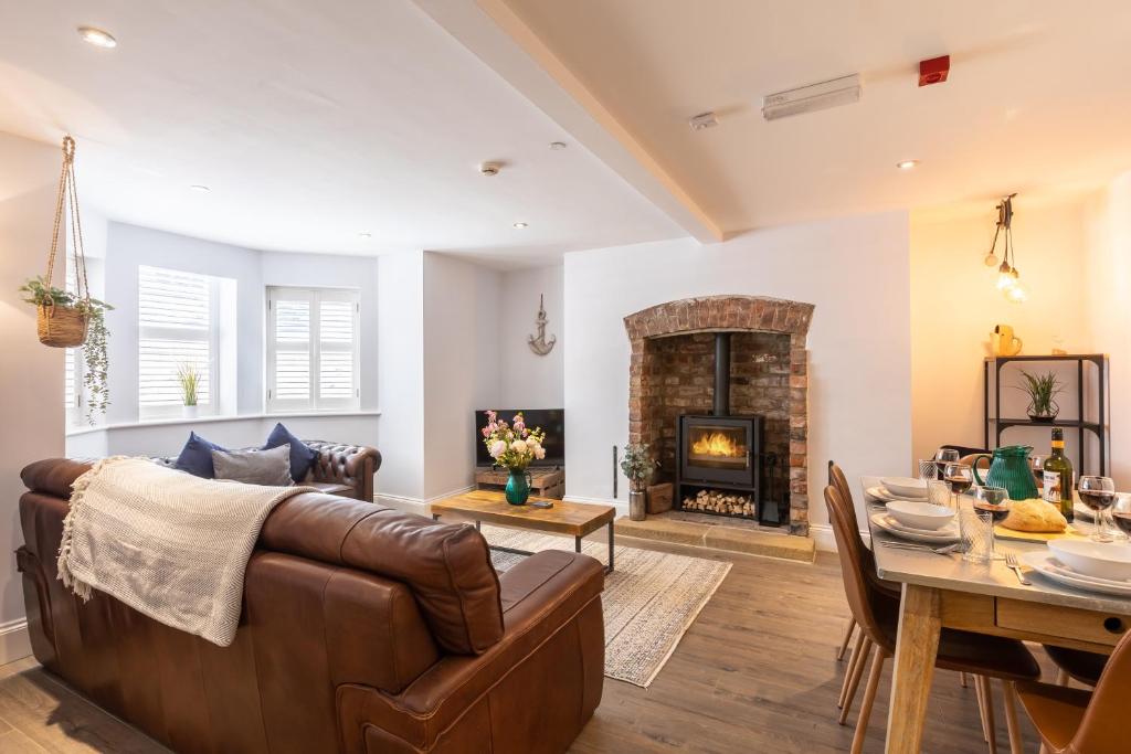 a living room with a couch and a table and a fireplace at The Servant’s Quarters in Whitby