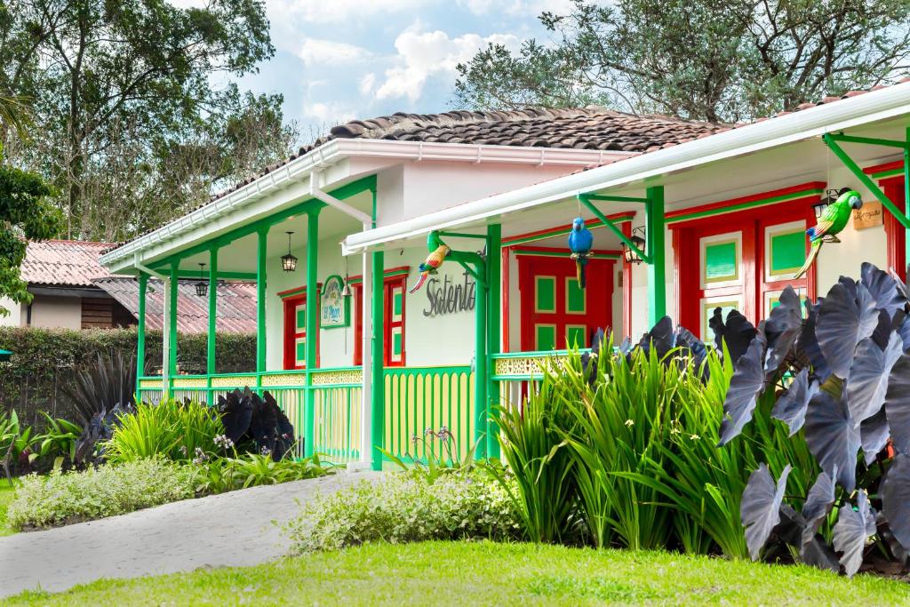 uma casa com acabamento verde e vermelho em Hotel Mirador de Boquia Salento em Salento