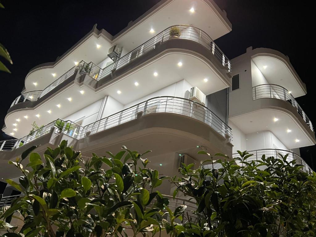 a large white building with lights on it at night at Dani's Apartments in Sarandë