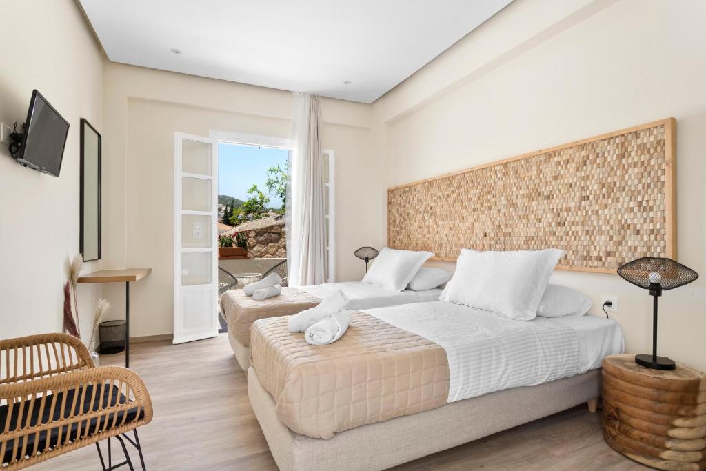 a bedroom with two beds and a television in it at Ethereal Stay in Spetses