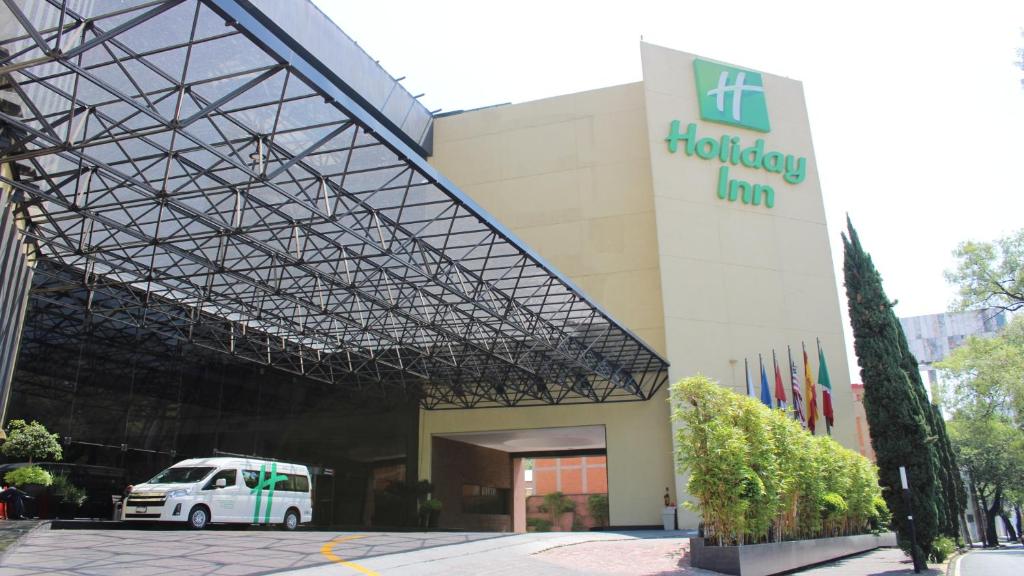 biały van zaparkowany przed budynkiem w obiekcie Holiday Inn Mexico Dali Airport, an IHG Hotel w mieście Meksyk
