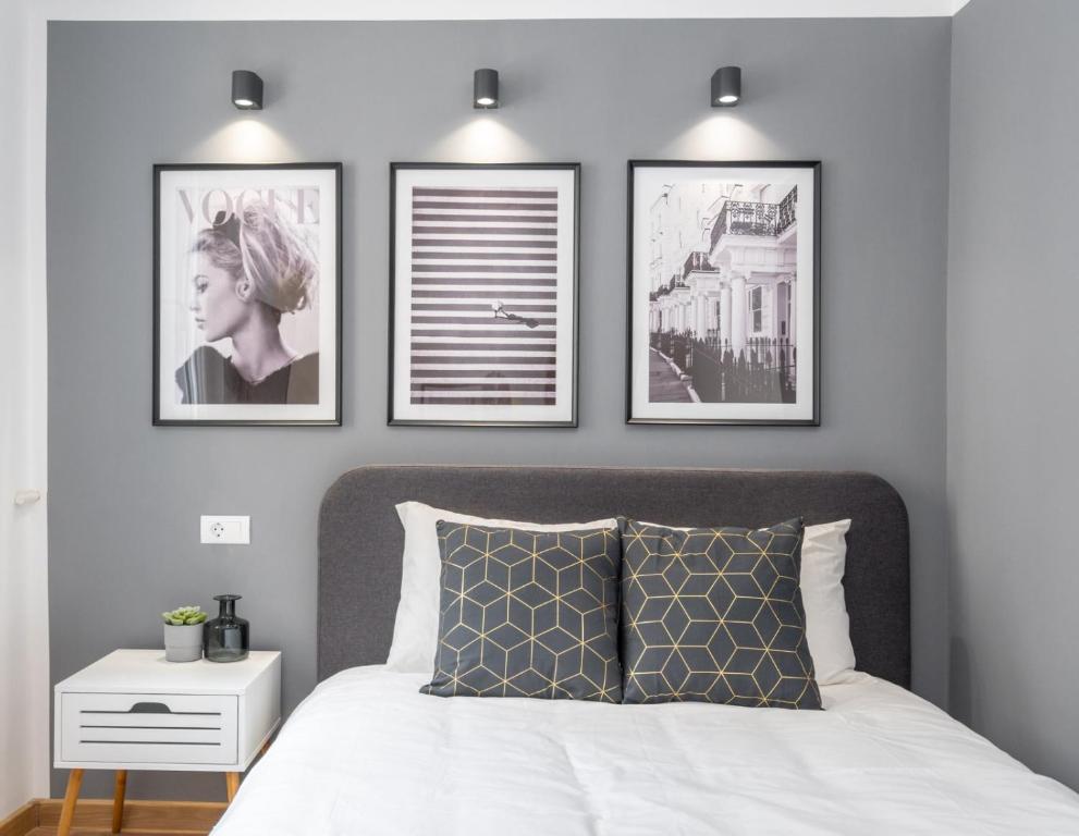 ein Schlafzimmer mit drei Bildern über einem Bett in der Unterkunft Relax Apartament in Piata Universitatii in Bukarest