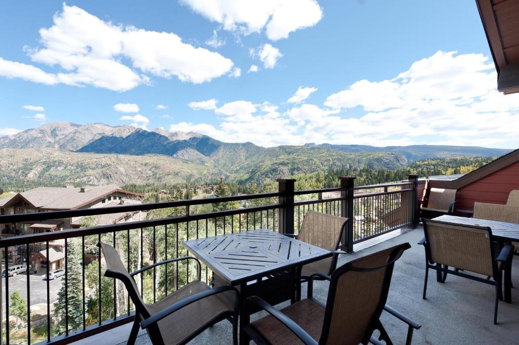 a balcony with a table and chairs and mountains at Purgatory Lodge Unit 501 in Durango Mountain Resort