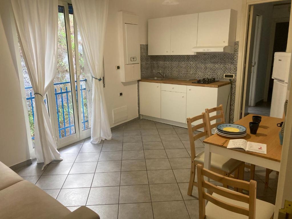 kuchnia z białymi szafkami oraz stołem i krzesłami w obiekcie Maison Clemi w Sorrento