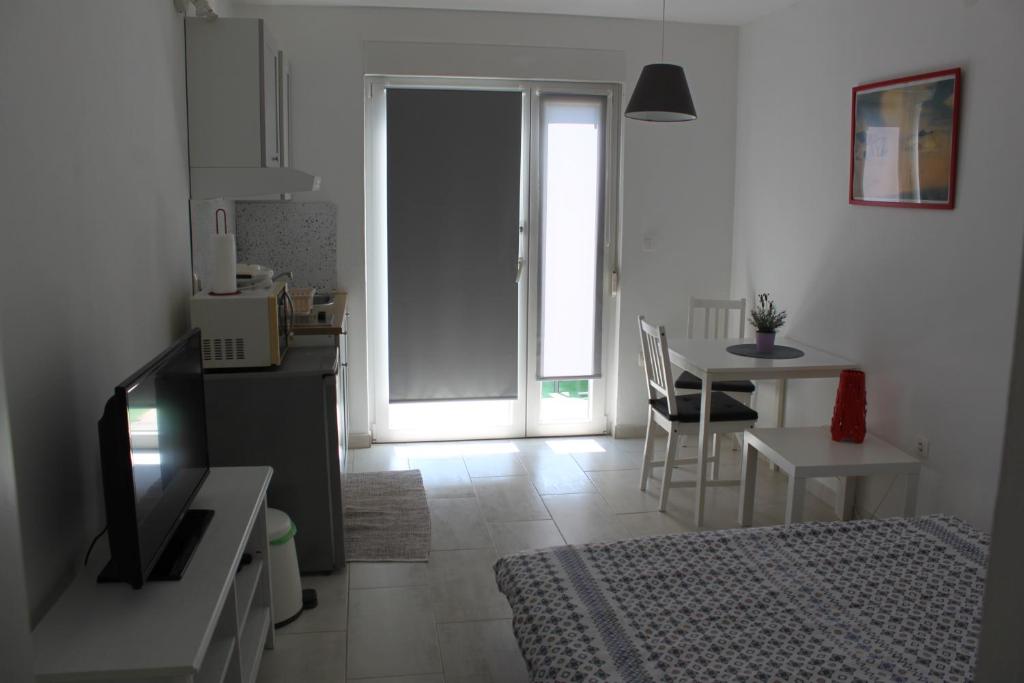 a living room with a kitchen and a dining table at Apartments Estelle in Pula