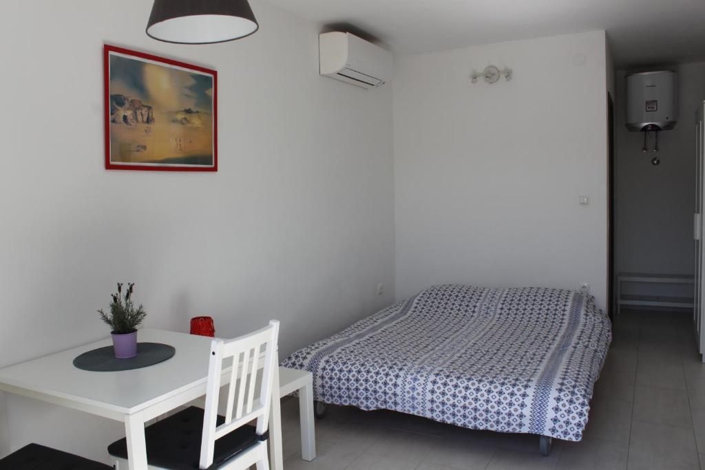 a bedroom with a bed and a table and a table and chair at Apartments Estelle in Pula