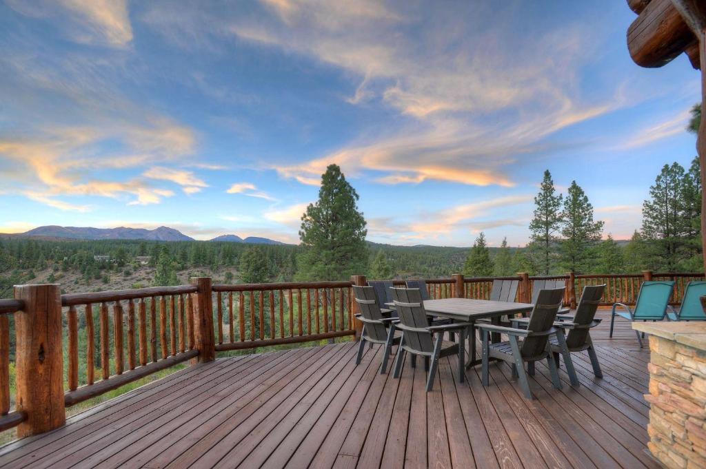 una terraza de madera con mesa y sillas. en Elk Mountain Retreat en Durango