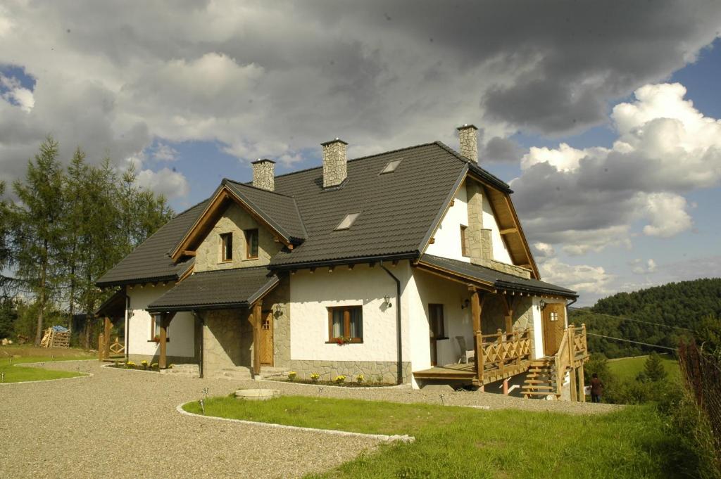a house with a black roof on top of it at Biały Wierch Bieszczady in Polańczyk