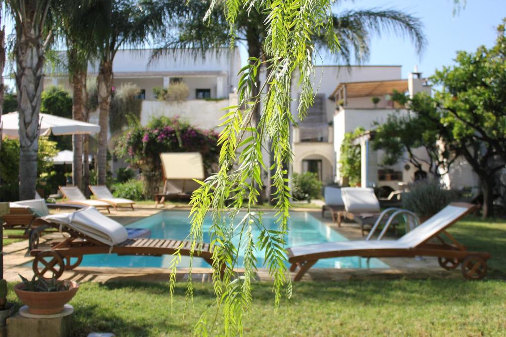 a pool with chaise lounge chairs and a pool at Le Stanze del Monsignore in Novoli