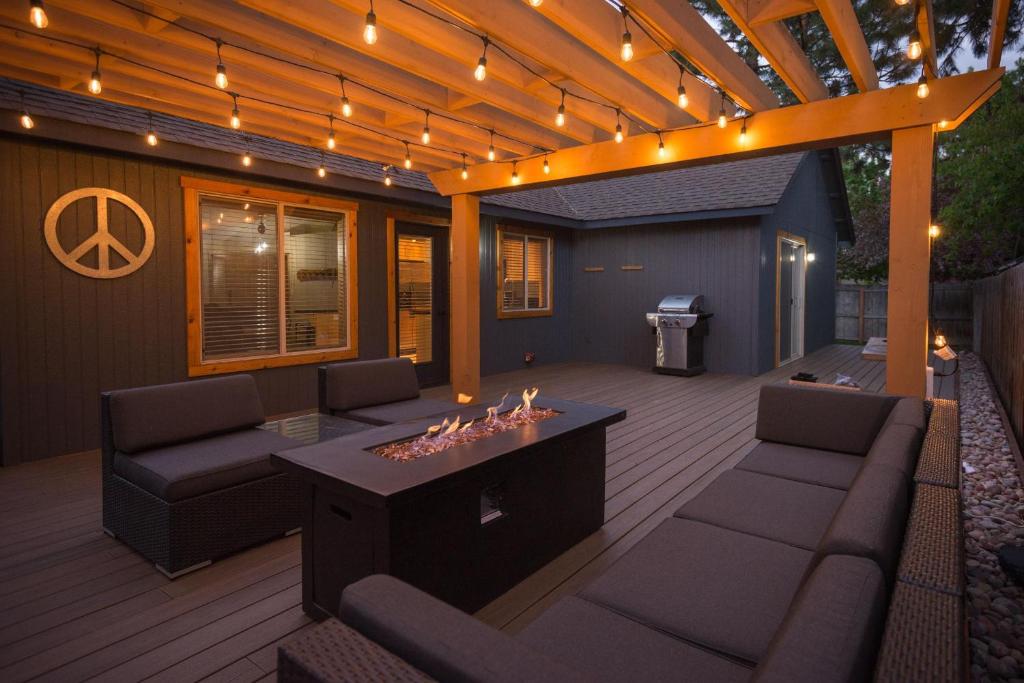 a patio with furniture and a pergola with lights at The Quails Nest in Bend