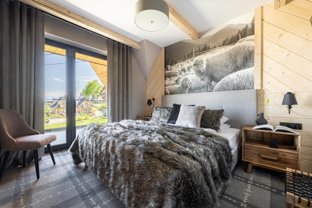 um quarto com uma cama e uma grande janela em VILLA TEDDY BEAR Zakopane em Zakopane