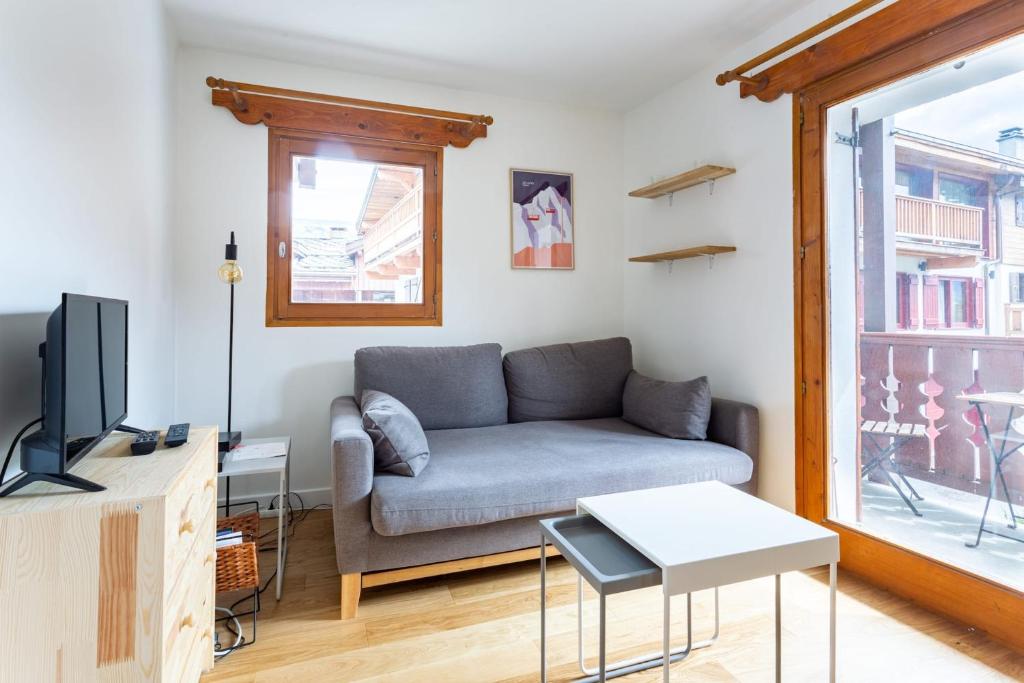 a living room with a couch and a tv at Very Bright Cocoon With Balcony Near The Slopes in Courchevel