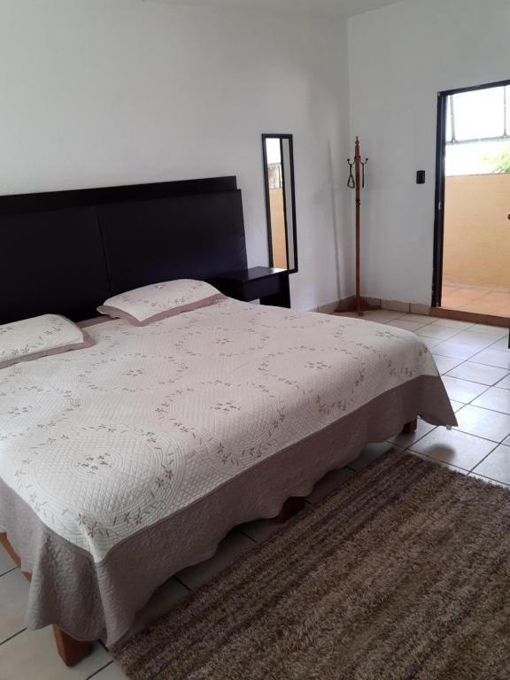 um quarto com uma cama grande e uma cabeceira preta em Posada Bugambilias em Tepoztlán