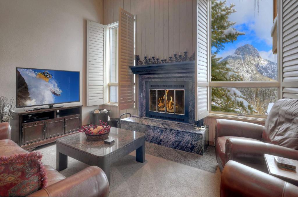 sala de estar con chimenea y TV en Cascade Village 35, en Durango Mountain Resort