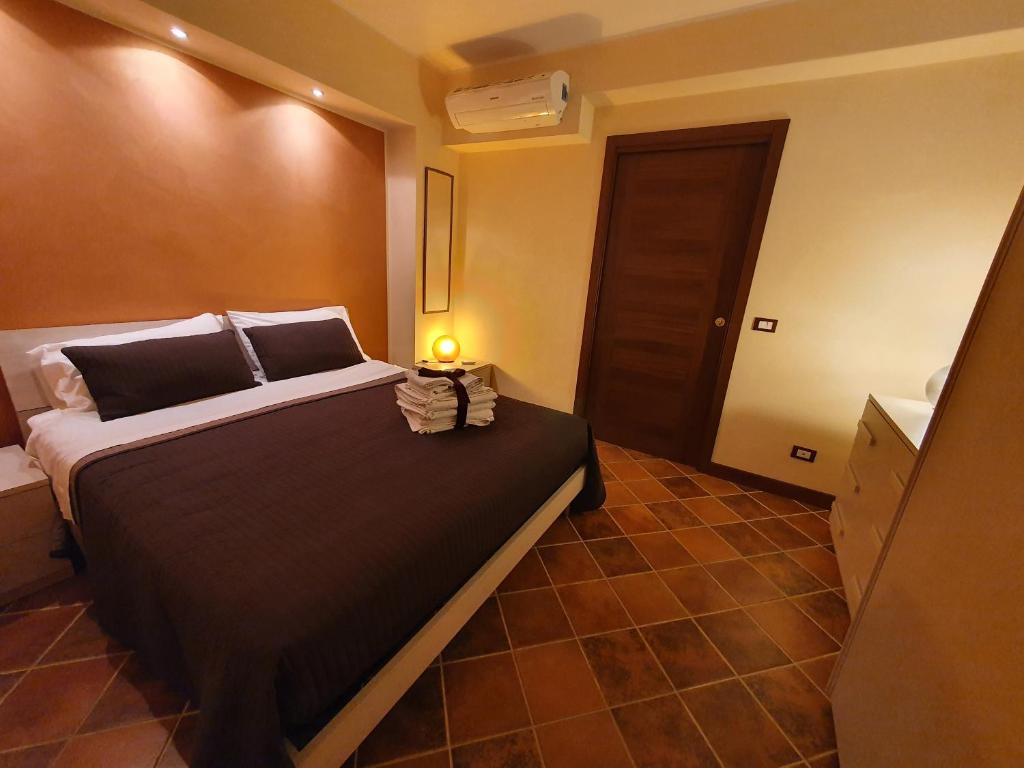 1 dormitorio con 1 cama grande y lámpara. en Casa La Ferula apt2 vicino al mare e Taormina con balcone, en SantʼAlessio Siculo
