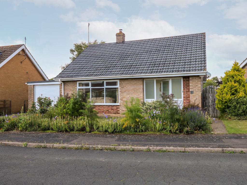 a brick house with a garden in front of it at Newby in Gayton