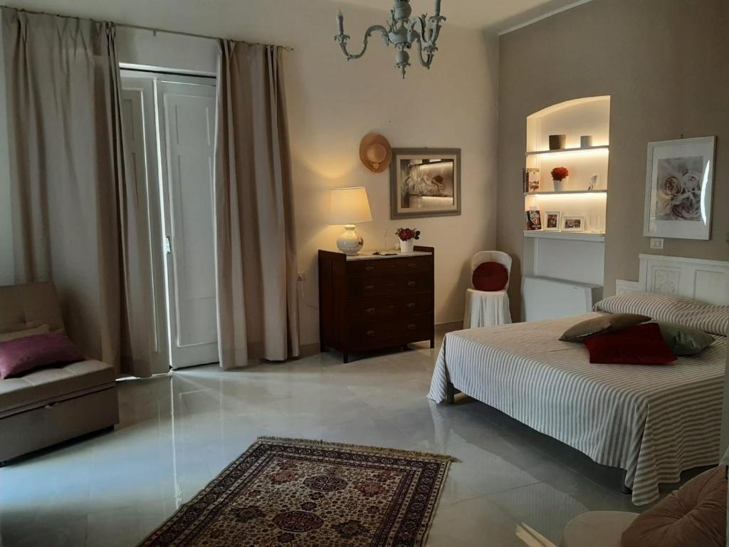 a bedroom with a bed and a chair in it at La Vie En Rose - Casa vacanze in Diamante