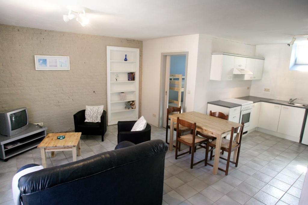 Apartment 't Maanhof في Gingelom: غرفة معيشة مع أريكة وطاولة ومطبخ
