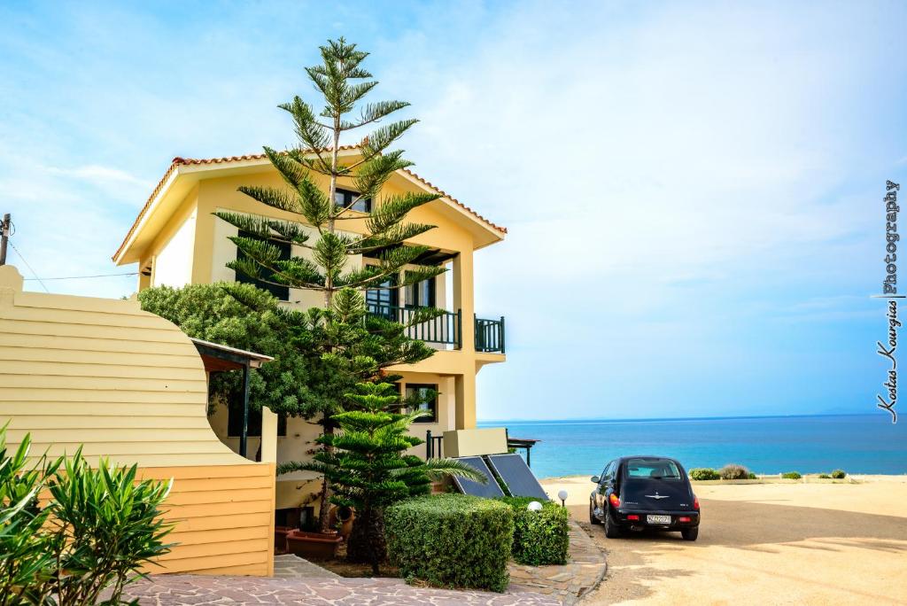 una casa con un coche estacionado junto a la playa en Villa Corali, en Karfas