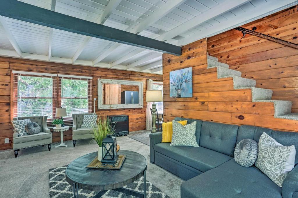 a living room with a blue couch and a staircase at Cozy Shaver Lake Cabin Less Than 1 Mi to Shaver Lake! in Shaver Lake