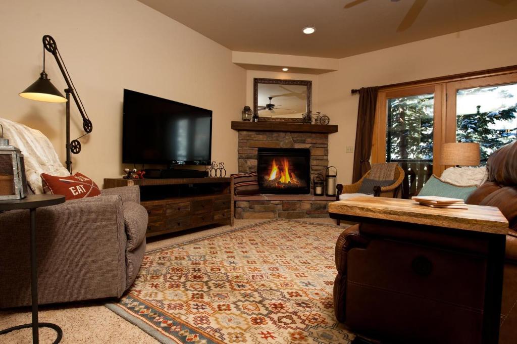 ein Wohnzimmer mit Kamin und Fernseher in der Unterkunft Black Bear 59 in Durango Mountain Resort