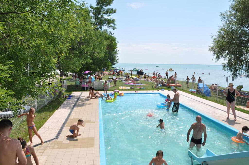 - un groupe de personnes dans la piscine de la plage dans l'établissement NaturExpert Mobil házak-Pelso Kemping Alsóörs, à Alsóörs